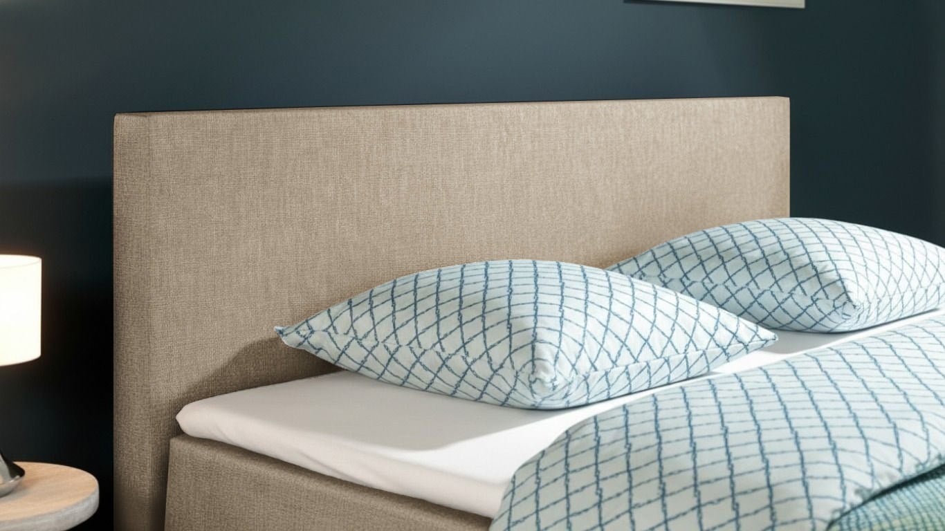 Detailopname van een elegant gestoffeerd hoofdbord bij een hotelbox-bed, focus op design.